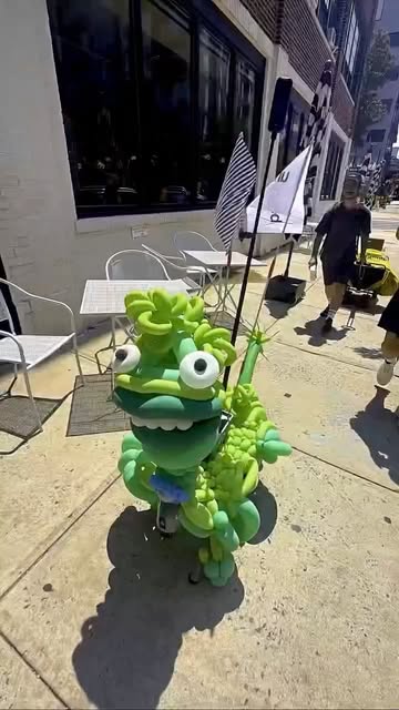 The green Unhinged mascot out on the sidewalk