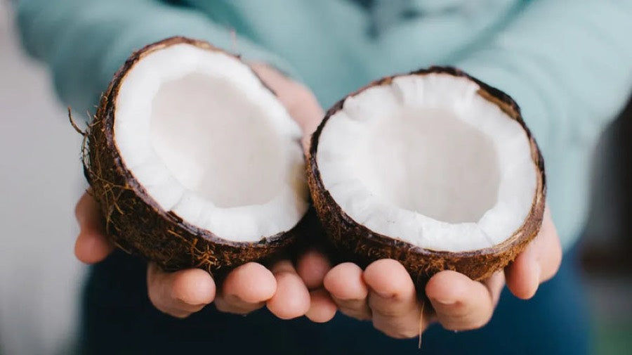 A split coconut held in two hands